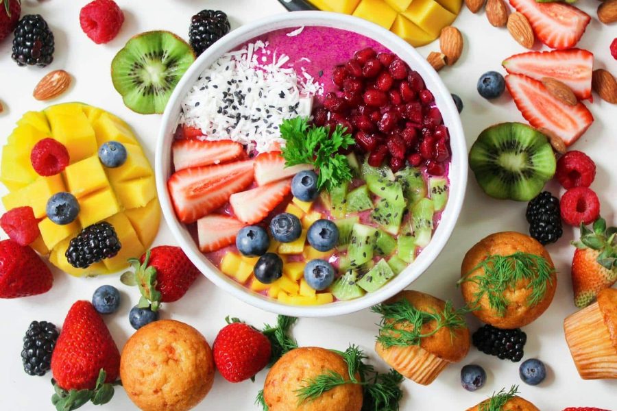 Vibrant smoothie bowl topped with assorted fresh fruits and muffins, perfect for a healthy snack.