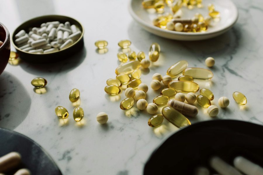 A close-up of assorted pills and supplements arranged on a marble surface, highlighting healthcare and wellness themes.