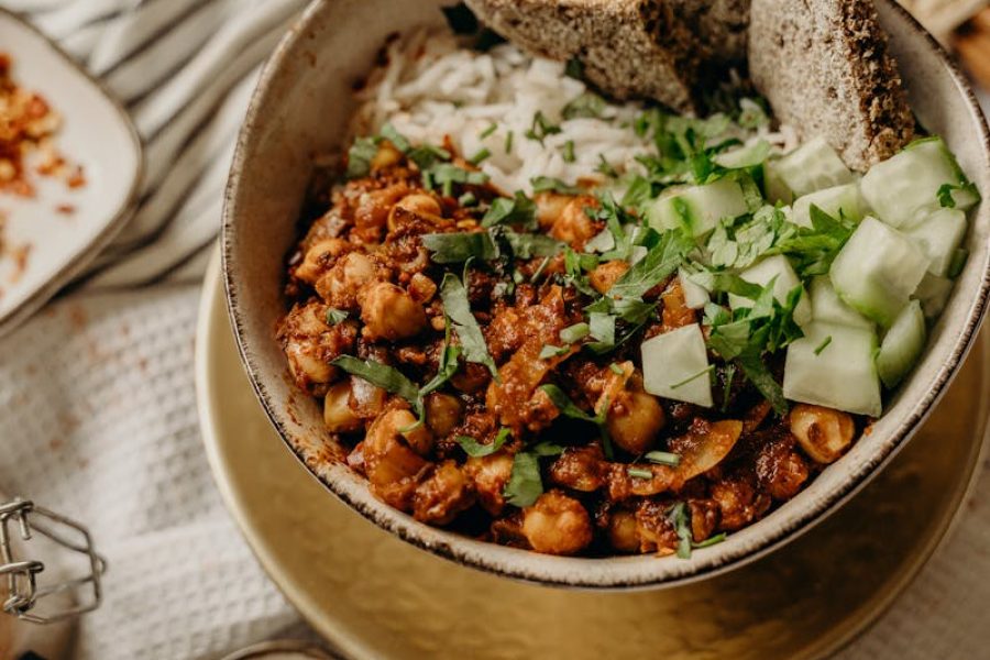 Delicious vegan bowl featuring chickpeas, rice, cucumber, and bread, perfect for a healthy meal.