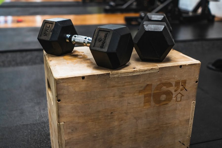 black and gray dumbbells on brown wooden crate