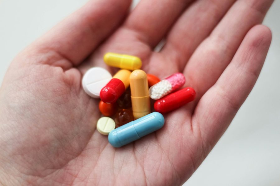 orange and white medication pill on persons hand